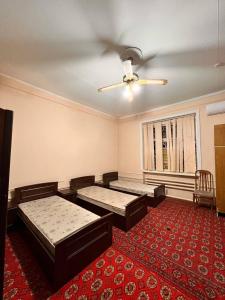 a room with two beds and a red carpet at Hello Hostel in Samarkand