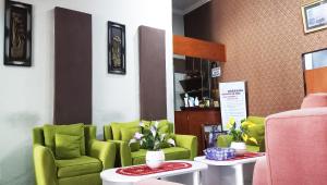 une salle d'attente avec des chaises et des tables vertes dans l'établissement Grand S'kuntum Hotel Syariah, à Metro