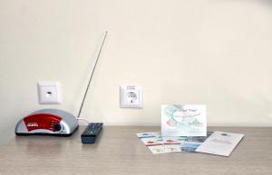 a red telephone and a book on a table at IT Time Hotel in Minsk