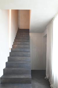una escalera en una casa con suelo de madera y paredes blancas en High end private room with private bathroom en Gante