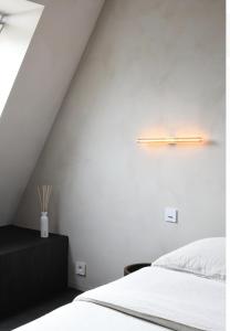 a bedroom with a white bed and a white wall at High end private room with private bathroom in Ghent