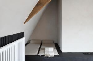 a bed in the corner of a room at B&B deZwarteFles in Ghent
