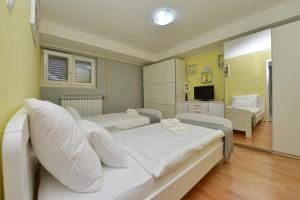 a bedroom with two beds and a living room at D&J Apartment Zadar in Zadar
