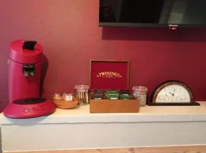 a counter with a red blender and a clock on it at Appartement le bar du JURA in Saint-Claude