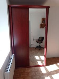 une porte ouverte menant à un bureau avec une chaise dans une pièce dans l'établissement Appartement le bar du JURA, à Saint-Claude