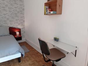 - une chambre avec un bureau, un lit, un lit et une chaise dans l'établissement Appartement le bar du JURA, à Saint-Claude