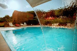 a water fountain in front of a swimming pool at Sotto Il Cielo Hotel in Pignola