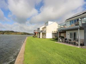 a large house with a lawn next to a body of water at Seaclusion in Y Felinheli