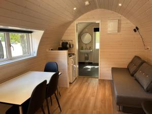 een tiny house met een tafel en een bank bij Helle Aktivitetshotel in Årre