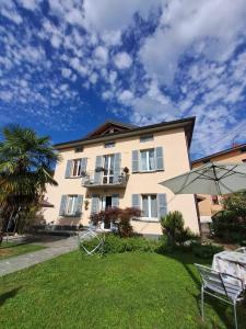 a large building with a table and an umbrella at B & B Ametista Bergamo in Ponteranica