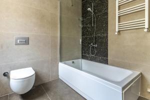 a bathroom with a tub and a toilet and a shower at Sea View Flat w Balcony Near Beylerbeyi Palace in Istanbul