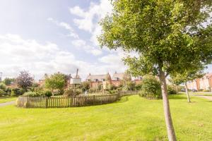 a tree in a field with houses in the background at Park view house, sleeps 5 or 6 suitable for contractors and families in Kibworth Harcourt