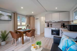 シャルボイツにあるOstseecamp Ferienhaus "Karin"のキッチンとテーブルとソファのあるリビングルーム