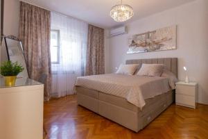 a bedroom with a bed and a chandelier at Apartman Dragomir in Imotski