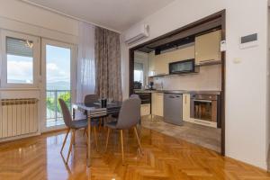 a kitchen and dining room with a table and chairs at Apartman Dragomir in Imotski