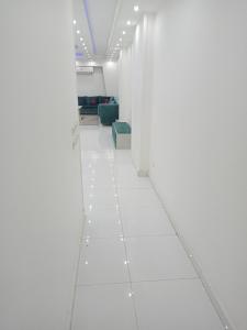 a hallway with white walls and a white floor at El Mohandesen in Cairo