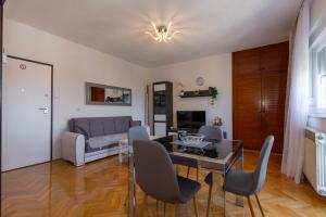 a living room with a table and chairs and a couch at Apartman Dragomir in Imotski