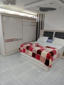 a bedroom with a bed with a checkered blanket at El Mohandesen in Cairo