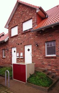 a red brick house with three white doors at Ataraxia in Insel Poel