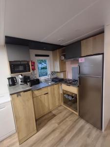加斯泰Mobil-home Camping Siblu La Reserve ****的配有木质橱柜和不锈钢器具的厨房
