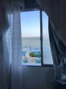 a window with a view of the ocean at Casa Abel Hotel in Araruama