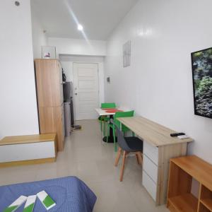 Habitación con escritorio, mesa y nevera. en Affordable Condo w/ Shower Heater and Wi-Fi, en Minglanilla