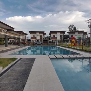 una piscina frente a algunas casas en Affordable Condo w/ Shower Heater and Wi-Fi, en Minglanilla