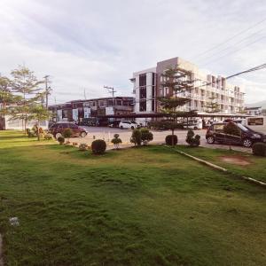 a park with cars parked in front of a building at Affordable Condo w/ Shower Heater and Wi-Fi in Minglanilla