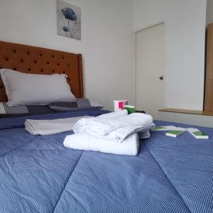 1 dormitorio con 2 toallas blancas en una cama en Affordable Condo w/ Shower Heater and Wi-Fi, en Minglanilla