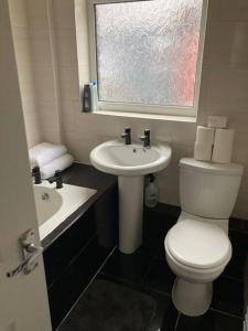 a bathroom with a toilet and a sink and a window at City and football in Liverpool