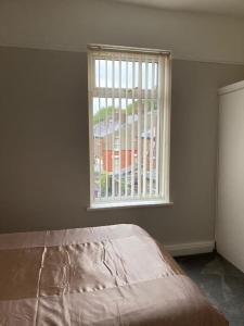 a bedroom with a window and a bed in front of it at City and football in Liverpool