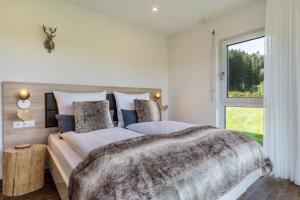 a bedroom with a large bed and a window at Tischneck Chalets in Hardt