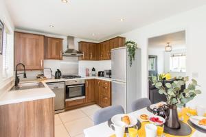 a kitchen with wooden cabinets and a white refrigerator at Park view house, sleeps 5 or 6 suitable for contractors and families in Kibworth Harcourt