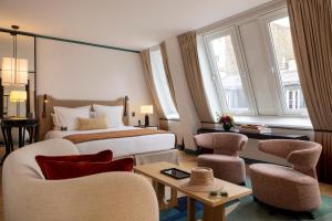 a hotel room with a bed and two chairs at Hôtel Bel Ami in Paris +85 photos