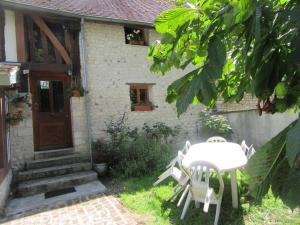 a table and chairs in front of a house at Appartement au bord de l'Eure in Léry