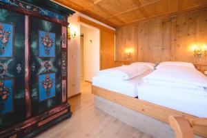 een slaapkamer met 2 bedden in een kamer met houten wanden bij Haus Barbarahof in Altenmarkt im Pongau