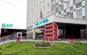 a hotel building with a flower bed in front of it at IT Time Hotel in Minsk