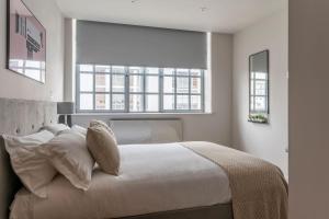 um quarto com uma grande cama branca e uma janela em Amigos Nest - Farringdon - by Frankie Says em Londres