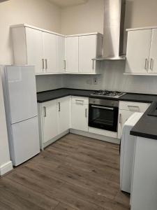 a kitchen with white appliances and white cabinets at City and football in Liverpool