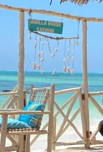 a beach chair with a sign that readsulum house karma at Vanilla House in Jambiani