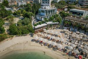 卡薩米里的住宿－HOTEL DENOEL，享有海滩的空中景致,配有椅子和遮阳伞