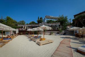 a group of lounge chairs and umbrellas on a beach at HOTEL DENOEL in Ksamil