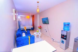 a living room with a blue couch and a video game at Enac Homes - Classy, Elegant Executive Studios - Kiambu Road in Kiambu