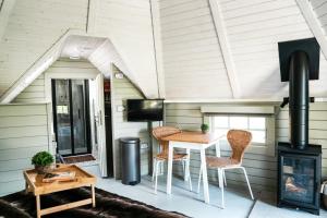 a room with a table and chairs and a stove at Mawgies Near Padstow in Saint Ervan