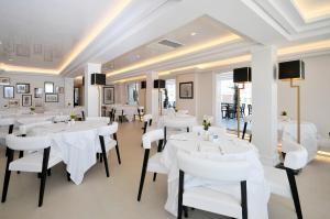 restauracja z białymi stołami i białymi krzesłami w obiekcie Grand Hotel Oriente w mieście Neapol