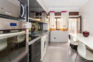 a kitchen with a counter and some chairs in it at The whole villa, near a large park and a quiet beach in Barreiro