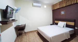 Cette chambre comprend un lit et une télévision. dans l'établissement Grand S'kuntum Hotel Syariah, à Metro