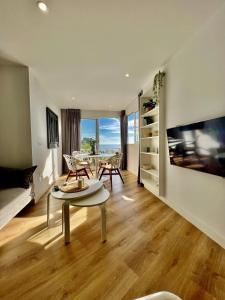 een woonkamer met een tafel en uitzicht op de oceaan bij PARAISO DEL SOL in Benajarafe