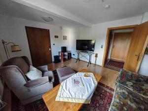 uma sala de estar com um sofá e uma mesa de centro em Apartment O1 - Gut ausgestattete 3-Zimmer Wohnung 78qm für 1-3 Personen 1xDZ 1xEZ em Grafenwöhr