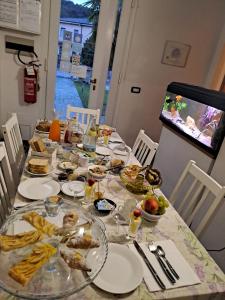 una mesa larga con platos de comida. en B & B Ametista Bergamo, en Ponteranica